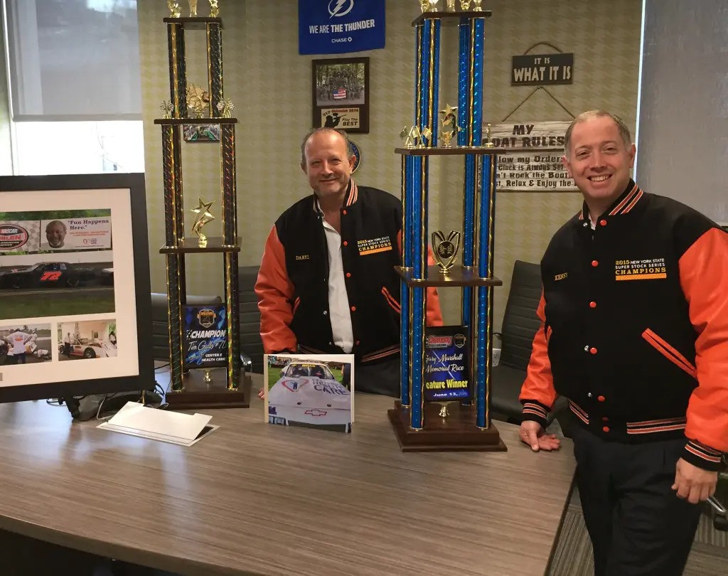 The co-owners of Centers for Care, Kenneth Rozenberg and Daryl Hagler, posing with a NASCAR Super Stock New York state championship trophy, will pay a total of $45 million after being accused of stealing nearly twice as much. Centers Health Care