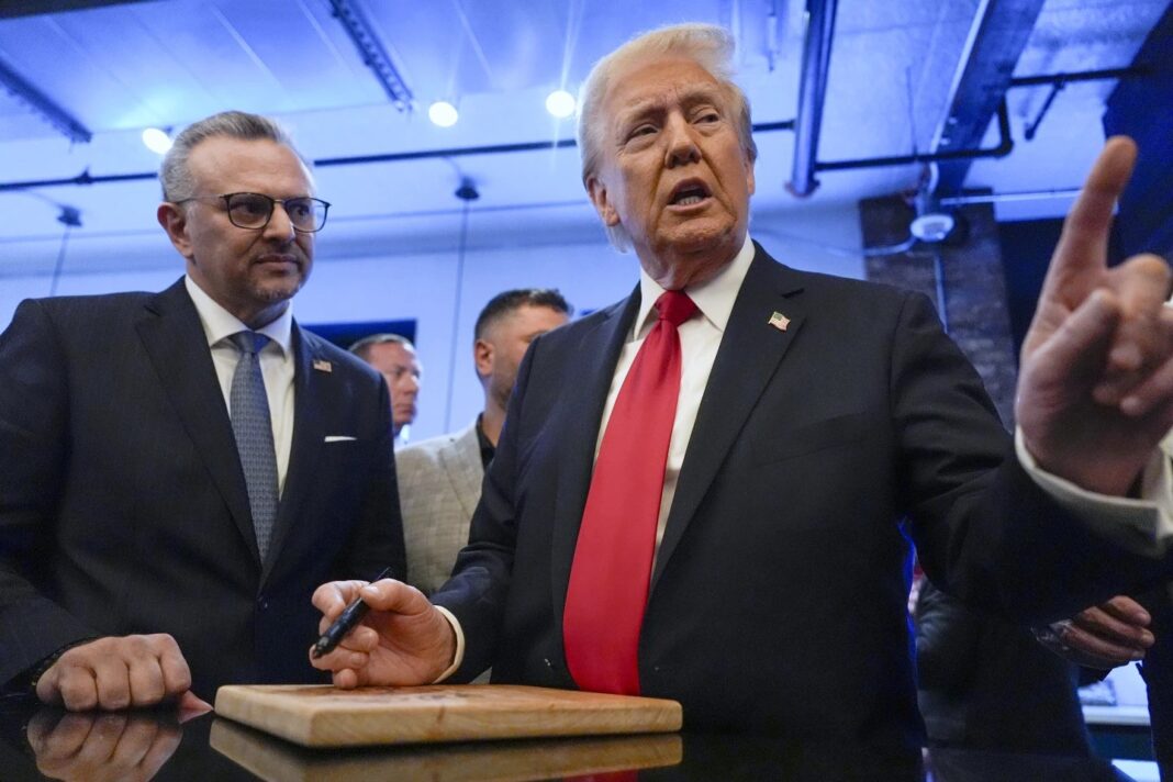 Republican presidential nominee former President Donald Trump signs autographs as Massad Boulos listens during a visit to The Great Commoner, Nov. 1, 2024, in Dearborn, Mich. (AP Photo/Julia Demaree Nikhinson, File)