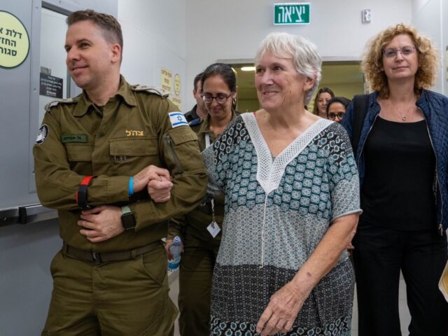 An IDF soldier escorts a freed hostage, November 24, 2023 (Government Press Office)