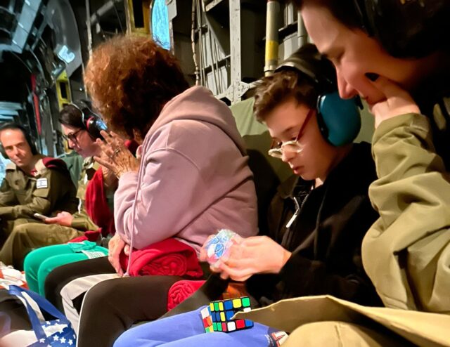 Freed hostage Ohad Munder, 9, plays with a Rubik’s cube that he was given aboard an IDF helicopter as he was transferred from Gaza to Israel, November 24, 2023 (Government Press Office)